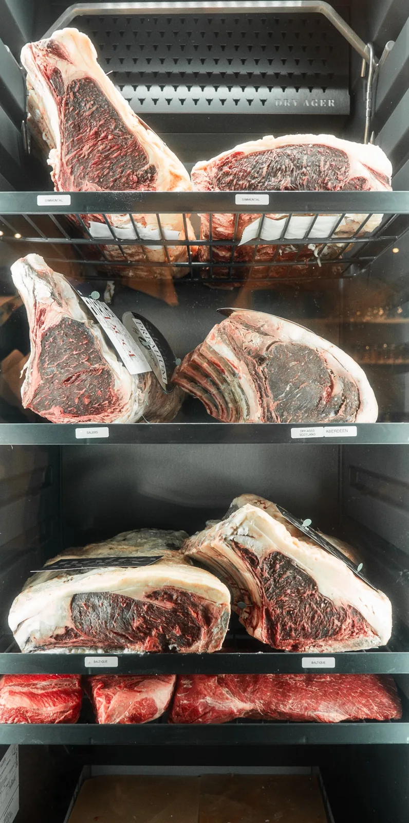 La cave de maturation vitrée, côtes de bœuf sur les étagères